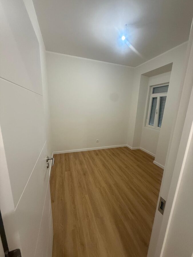 Finished bedroom with laminate flooring and painted walls